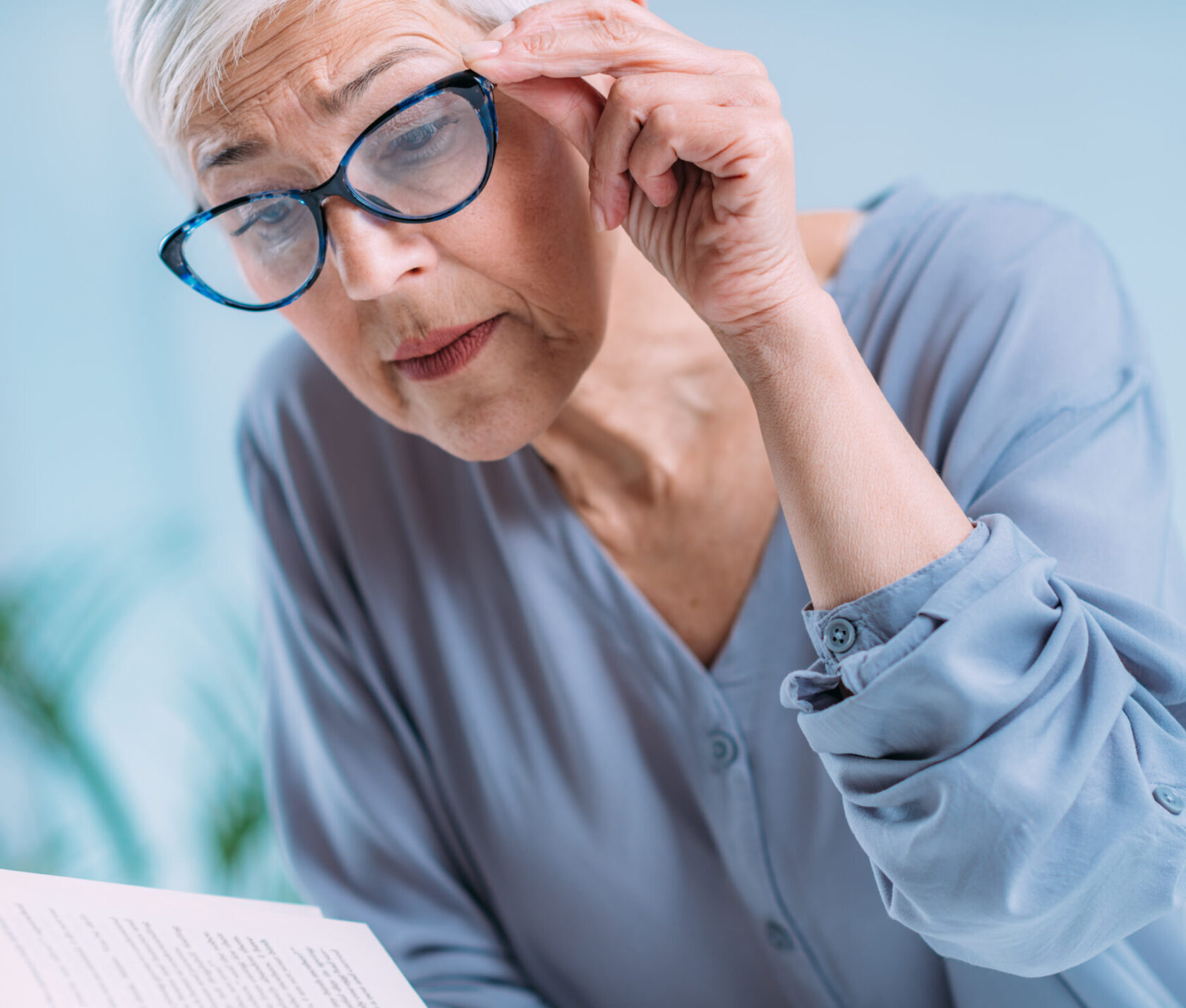 Glaucoma. Senior Woman a Reading Book, Having Ocular Tension.